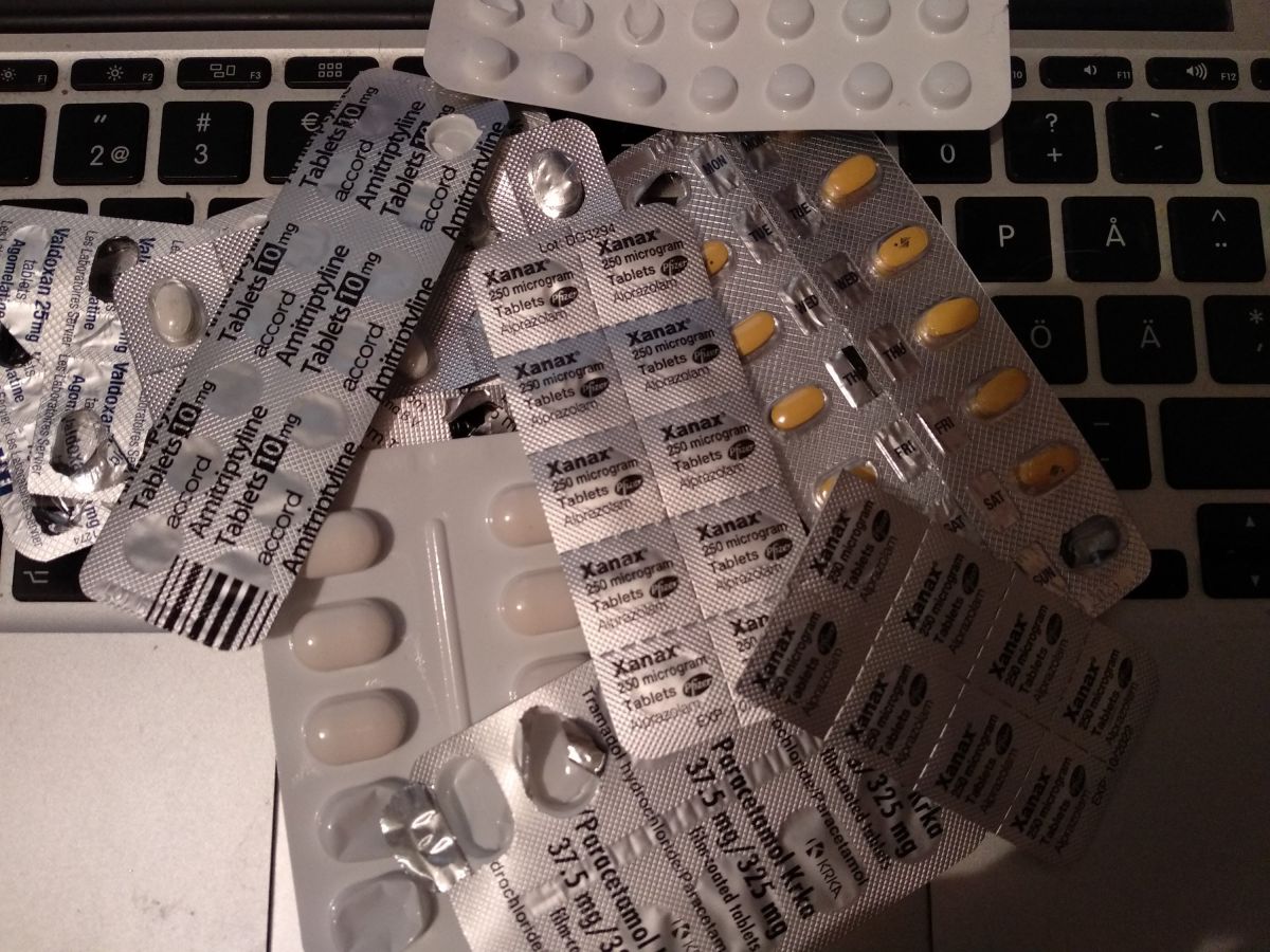 A pile of painkillers, antidepressants and benzos sitting on my junkbox laptop's keyboard.